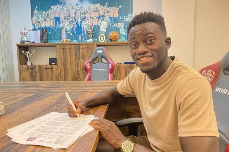 Kalifa Kujabi che mette la firma sul contratto con il Cluj