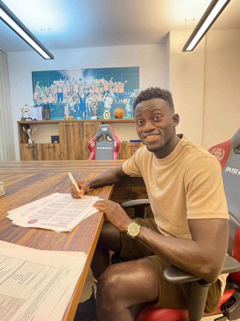 Kalifa Kujabi che mette la firma sul contratto con il Cluj